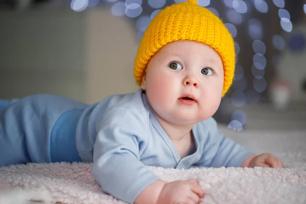 Portret van een jongetje dat in een blauw pak op zijn buik ligt — Stockfoto