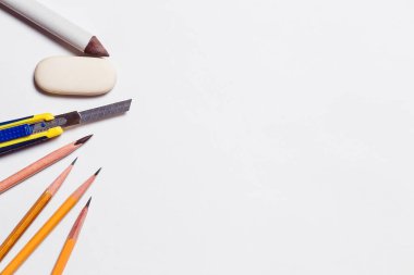 Beyaz backgrou üzerinde sanatçılar için kalemler ve silgi bıçak rastushka