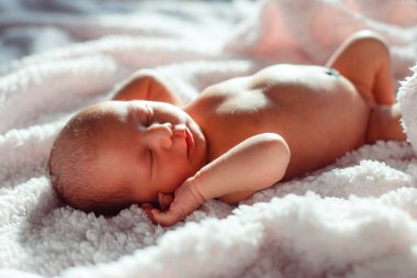 Yeni doğmuş bebek arka planda beyaz arka planda uyuyor.