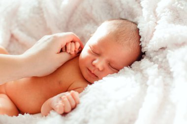 Anne el bir beyaz arka planda yeni doğmuş bir bebek tutan bir b