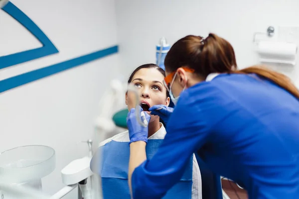 El paciente en el consultorio dental realiza un procedimiento doloroso —  Fotos de Stock
