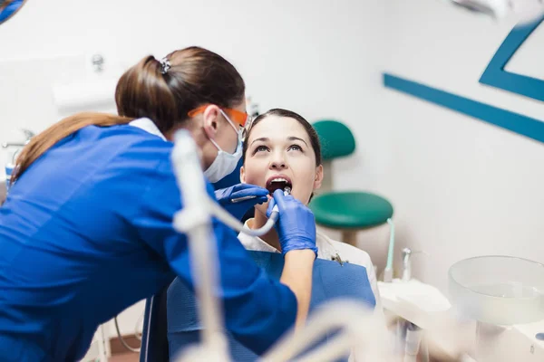 Diş hekimi bir resepsiyonda genç kadın hastaya — Stok fotoğraf