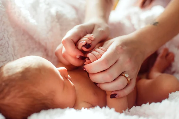 Mãe está de mãos dadas um bebê recém-nascido em um fundo branco em um b — Fotografia de Stock