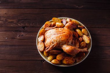 koyu ahşap arka plan üzerinde altın kabuk ile kızarmış tavuk (üst görünümü yakın)