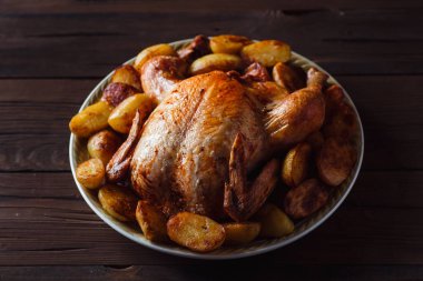 koyu ahşap arka plan üzerinde altın kabuk ile kızarmış tavuk (üst görünümü yakın)