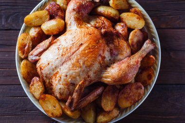 koyu ahşap arka plan üzerinde altın kabuk ile kızarmış tavuk (üst görünümü yakın)