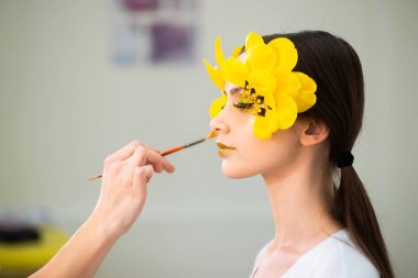 Makyaj sanatçısının işi. Lale şeklinde uzun kirpikleri olan bir esmerin güzel portresi. Gözünü kapat.