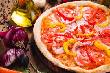 Venedik pizza jambon, domates ve malzemeler (yakın çevresinde koyu bir ahşap zemin üzerine kırmızı biber ile)