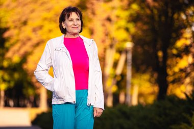 gün batımında parkta yaşlı bir gülümseyen kadının portresi