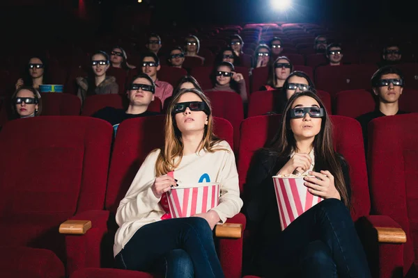 Девушки на сеансе кино едят попкорн — стоковое фото