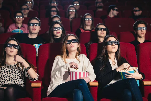 Meisjes vrienden in een bioscoop sessie het eten van popcorn — Stockfoto