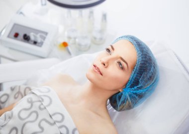 Müşteri bir kozmetolojistle bir resepsiyonda kanepede yatıyor.