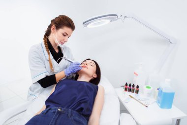 Kalıcı makyaj güzellik salonda dudaklarında sahip genç kadın.