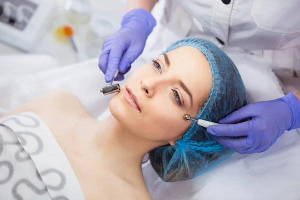 Închiderea feței tinere feminine în timpul terapiei cu microcurent . — Fotografie, imagine de stoc