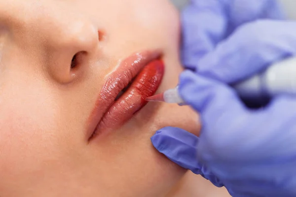 Jonge vrouw met permanente make-up op lippen in schoonheidsspecialist salon. — Stockfoto