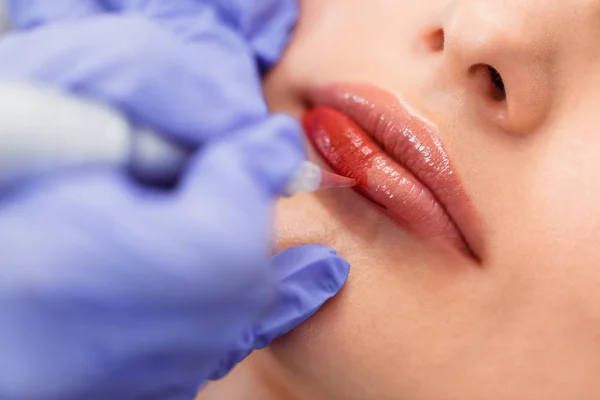 Jonge vrouw met permanente make-up op lippen in schoonheidsspecialist salon. — Stockfoto