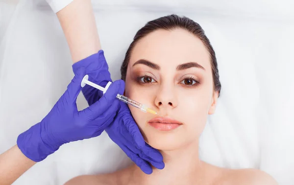 Arts cosmetologist injecteert het gezicht van de patiënt — Stockfoto