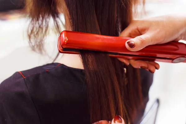 Estilista alinear el cabello del cliente con plancha — Foto de Stock