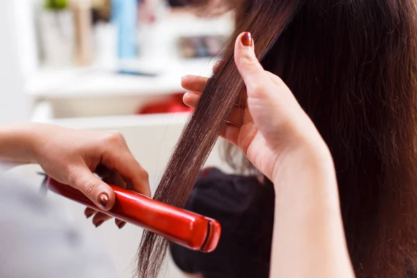 Estilista alinear el cabello del cliente con plancha — Foto de Stock