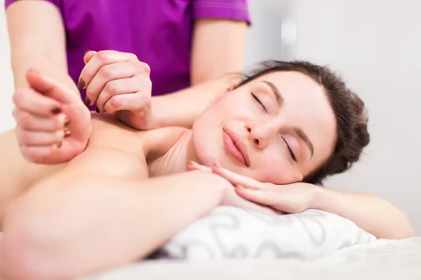 Schöne Brünette bei einer Massage in einem Wellnessbereich — Stockfoto