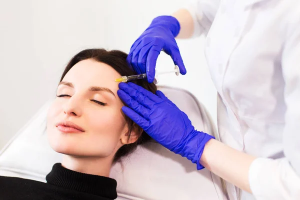 Доктор-косметолог вводит пациенту лицо — стоковое фото