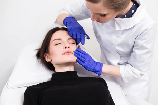 Arts cosmetologist injecteert het gezicht van de patiënt — Stockfoto