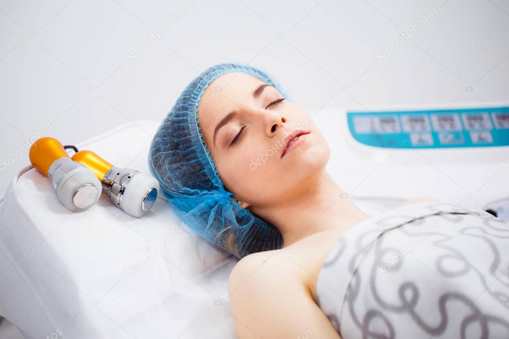The procedure of photoepilation in the beauty salon. A young wom