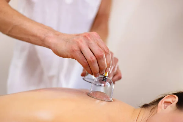 Young woman on the procedure of vacuum cupping massage.