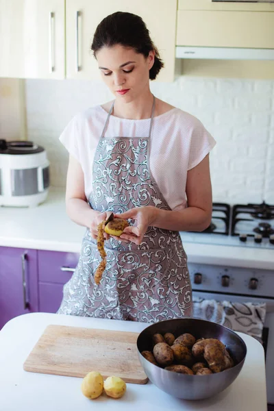 Jovem Mulher Cozinha Avental Descascando Batatas — Fotografia de Stock