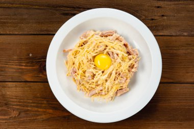 pastırmalı erişte, sahanda yumurta ve ahşap arka planda beyaz tabakta biber. Geleneksel İtalyan makarnası. Üst görünümü kapat