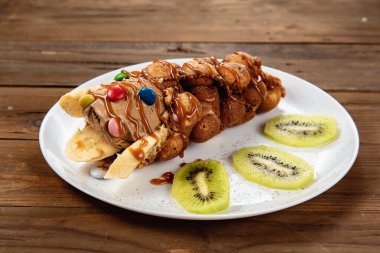 Gözleme külahında çikolatalı dondurma, içinde şeker ve meyve şurubu.