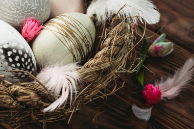 Dekoratif Paskalya yumurtalarını ahşap arka planda bir sepete koy. Mutlu Paskalyalar