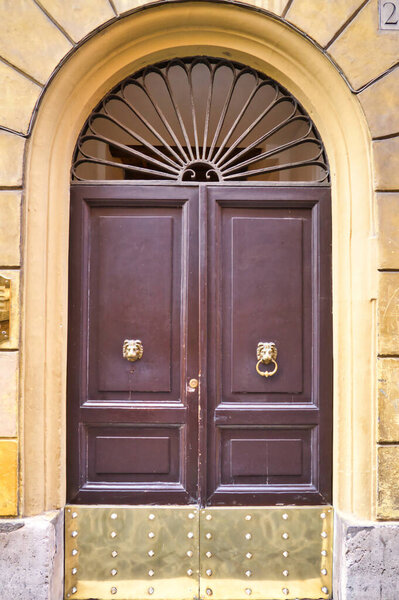 Рим, Италия - 15 июля 2018 года: старинный жилой дом с деревянной входной дверью и арочной рамой. Архитектура Рима, Италия