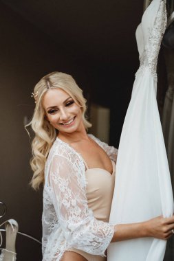 Gülümseyen ve gelinliğini gösteren genç bir gelinin portresi. Düğün fotoğrafları hazırlıyorum.