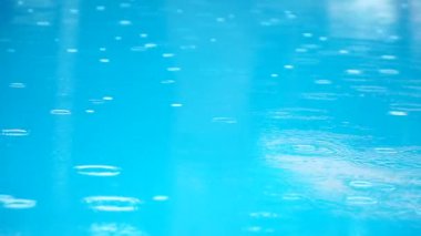 Havuzu, ağır çekim üzerinde yağmur damlaları.