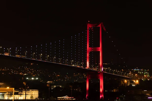 Boğaziçi Köprüsü kırmızı ışıklar ile Istanbul'da gece ışıklı.