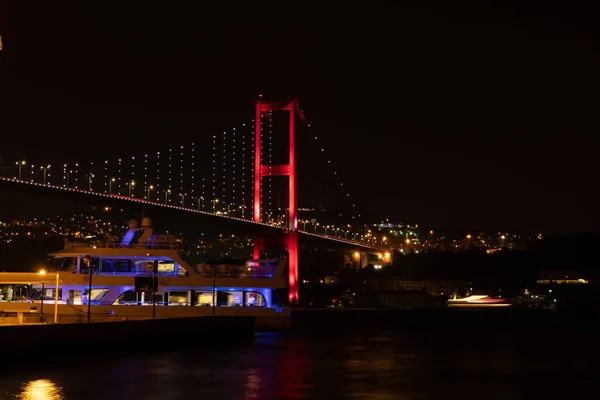 Boğaziçi Köprüsü kırmızı ışıklar ile Istanbul'da gece ışıklı.