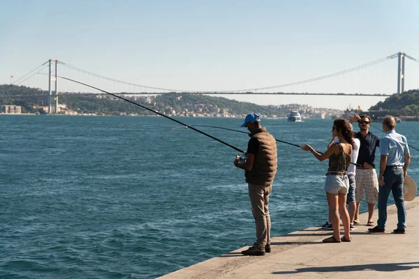 Istanbul, Türkiye - Temmuz 2018: balıkçılık balıkçılık çubuklar, Istanbul 'un sahil şeridi ile insanlar.