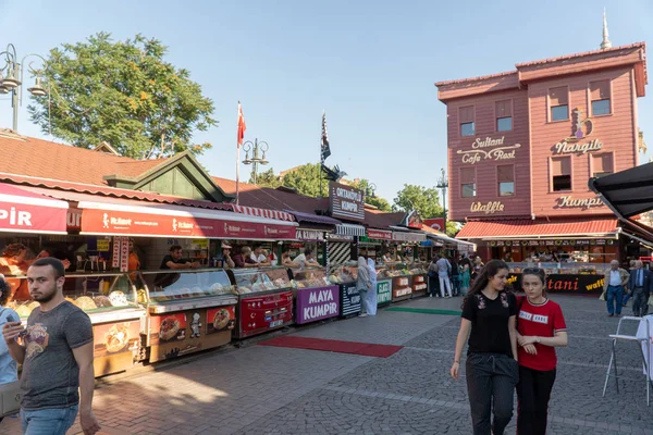 Istanbul, Türkiye - Temmuz 2018: Birçok kiosklar geleneksel Türk fastfood, canlı alanında ünlü Ortaköy İskelesi alanı gün zaman sunuyoruz. Satıcılar deneyin veya tatlı waffle yemek için yoldan geçenler tout ve patates destekli