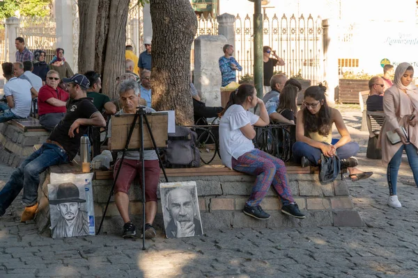 Istanbul, Türkiye - Temmuz 2018: Sokak portre ressamı ve siyah ve beyaz kurşun kalemle çizilen onun sanatının örnekleri.