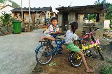 Wuzhishan, Hainan, Çin - 11 Eylül, 2015:Boy ve bisiklet Yahu köyde kızla