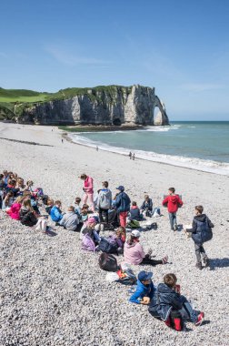 Etretat, Fransa - 5 Haziran 2014: Çocuklar piknik sahilde bir grup. Etretat üç doğal kemerli ve sivri uçlu iğne