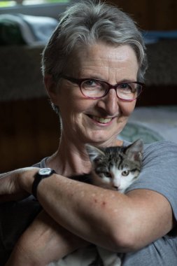 Neuf-Brisach, Fransa - 11 Haziran 2016: Kadın onunla feral kedi evlat edindi. O bir kedi evi oluşturulan ve 60'tan fazla feral cats beslemeleri