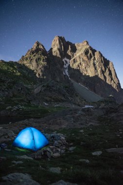 Yaz göğün ve ön planda mavi bir çadır ile Pic du Midi d'Ossau (2884 m). Fransızca Pyrenees Ossau Vadisi'nde yukarıda yükselen dağ