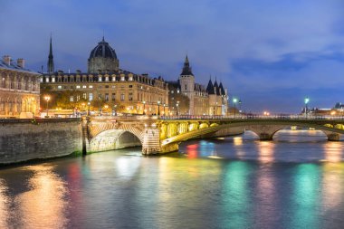 Conciergerie alacakaranlıkta Seine Nehri üzerinde bir köprü ile. Conciergerie Paris, Fransa, eski bir hapishane bir bina ama halen çoğunlukla hukuk mahkemeleri için kullanılan