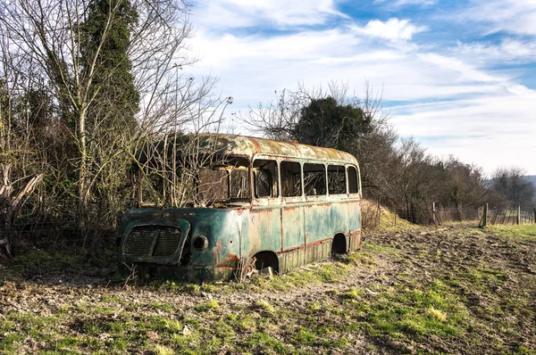 stripped rusty, old abandoned red bus wreck in the north of France