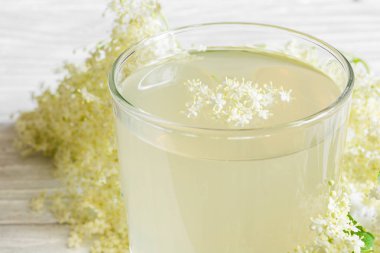 Beyaz ahşap zemin üzerinde mürver çiçeği içki. sağlıklı Bitkisel içki yakın çekim