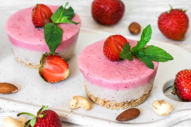 Vegan ham çilekli cheesecake taze çilek, nane ve fındık ile. sağlıklı vegan gıda kavramı