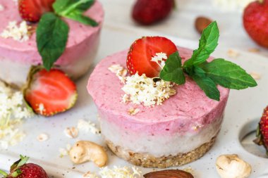 Vegan ham çilekli cheesecake taze çilek, nane, fındık ve yaşlı çiçekler ile. sağlıklı vegan gıda kavramı