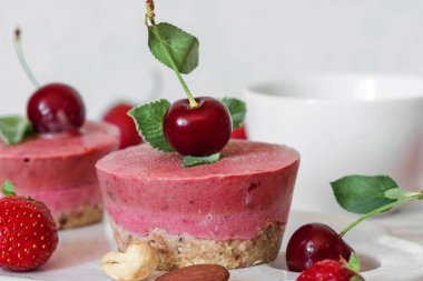 sağlıklı kahvaltı. Ev yapımı Çilekli ve kiraz cheesecakes taze çilek, nane, fındık ve kahve fincanı ile. vegan gıda kavramı